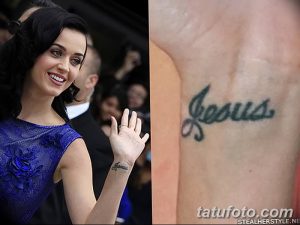 Фотография татуировки на запястье Кэти Перри, представляющей собой надпись 'Jesus'. Черно-белый рисунок выглядит просто и лаконично.