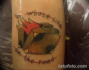 Фото тату на руке с изображением горящего чемодана и надписью 'Whole Life on the Road'. Рисунок выполнен в ярких цветах, в стиле олдскул.