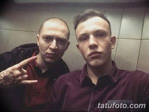 Фото двух мужчин с татуировками, смотрящих в камеру. Уличный стиль, неформальная обстановка, реалистичные портреты.
