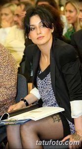 Фото тату: черная спираль на ноге женщины, дополняющая ее элегантный образ. Изящный рисунок татуировки, выполненный в минималистичном стиле.