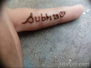 Фото тату с именем 'Dubha' и сердечком, выполненным хной на пальце руки. Простой и лаконичный рисунок.