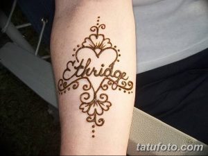 Фото тату хной на предплечье с именем 'Ethridge', заключенным в сердце и украшенным узорами.
