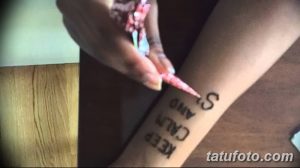 Татуировка на предплечье с надписью "Keep Calm and Carry On" (Сохраняй спокойствие и продолжай), выполненная черным цветом.