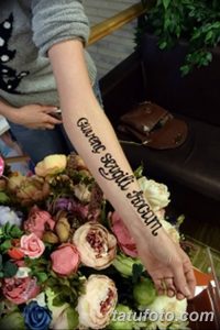 Фото тату с именем, написанным красивым каллиграфическим шрифтом на руке. Черные чернила, романтический стиль, эскиз татуировки.