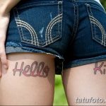 Фото татуировок на бедрах, изображающих надписи "Hello Kitty" в розовом цвете. Стиль - мультяшный, яркий и игривый.