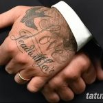 Фото тату Дэвида Бекхэма: надпись "Love Lead With Love" и изображение ласточки на руке, выполненные в элегантном стиле.