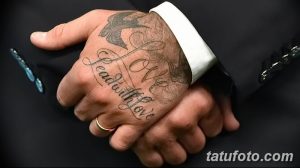 Фото тату Дэвида Бекхэма: надпись "Love Lead With Love" и изображение ласточки на руке, выполненные в элегантном стиле.
