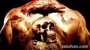 Фото тату на спине: черный ворон над черепом с надписью 'Expendable'. Детализированный рисунок с использованием темных оттенков.