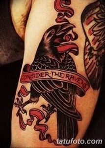 Фото тату ворона в шляпе с надписью "Consider the Ravens". Рисунок выполнен в стиле олдскул с использованием ярких цветов.