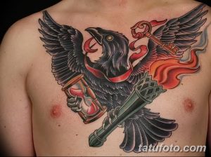Фото тату ворона на груди мужчины. Рисунок выполнен в стиле олдскул с использованием ярких цветов: черного, красного, желтого и синего.
