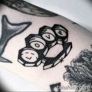 Фото геометрической татуировки кастетов, выполненной в стиле blackwork на руке.