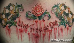 Фото тату: красочный рисунок кастета, розы и надписи "Live Free or Die" на груди, выполненный в стиле traditional tattoo.
