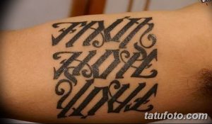 Фото татуировки на предплечье: фраза "Faith Hope Love" написана готическим шрифтом. Стильный дизайн для любителей готики.