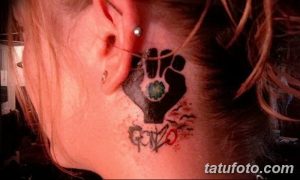 Фото тату поднятой руки на шее. Минималистичный рисунок татуировки в черном цвете, символизирующий силу и протест.