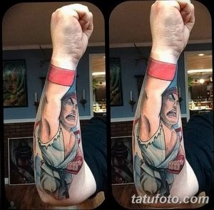 Фото тату Рю из Street Fighter на руке. Цветной рисунок татуировки с изображением персонажа видеоигры в динамичной позе.