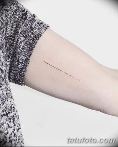 Фото тату минималистичной линии на руке, выполненной в черном цвете. Изображение выглядит просто и элегантно.