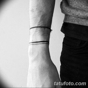 Фото тату на запястье. Две тонкие черные линии, расположенные горизонтально, имитирующие браслет, создающие минималистичный и стильный образ.