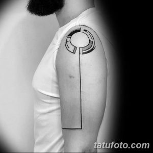 Фото тату на плече. Черно-белый минималистичный рисунок, состоящий из круга и вертикальной линии, создающий простой и элегантный образ.