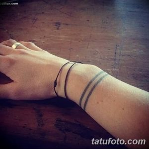 Фотография минималистичной татуировки на запястье, состоящей из двух параллельных черных линий.