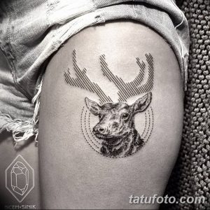 Черно-белая татуировка головы оленя, выполненная в геометрическом стиле с использованием линий и точек, на бедре девушки.