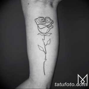 Изящная татуировка розы, выполненная одной линией на руке. Простой, но элегантный дизайн, подчеркивающий красоту цветка.