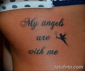 Фото тату: надпись 'My angels are with me' и изображение маленькой феи с крыльями на плече девушки.