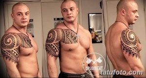 Фото тату в стиле полинезийских узоров на плече мужчины. Черные геометрические орнаменты покрывают плечо и часть груди.