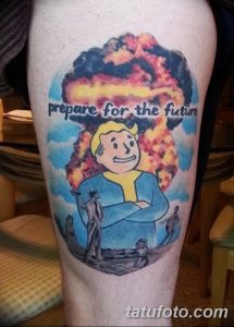 Фотография цветной татуировки в стиле игры Fallout с изображением Vault Boy на фоне ядерного взрыва и силуэтами людей. Идея для фанатов игр.