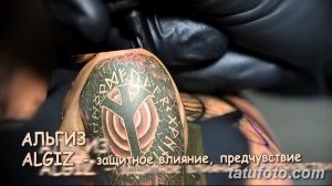 Фото тату на плече: руна Альгиз, окруженная руническими символами, выполненная в черном и сером цветах. Детализированный и символичный рисунок.