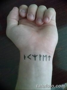 Фото тату на руке: короткая руническая надпись, выполненная в черном цвете. Простой и лаконичный дизайн.