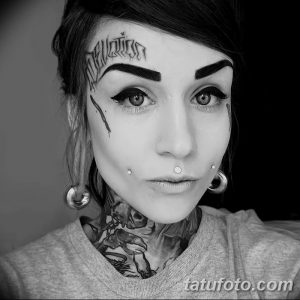 Фото тату: девушка с татуировками в стиле blackwork на лице, шее и плече. Черно-белый рисунок татуировки.