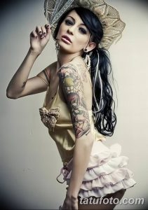Фото тату: стильная девушка в золотом платье с множеством татуировок на руках, демонстрирует татуировки крупным планом.