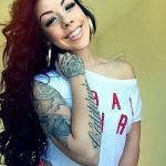 Фото татуировки розы с надписью "California" на руке девушки. Эскиз тату выполнен в черно-серых тонах.