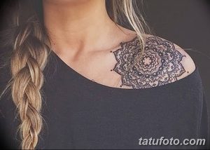 Фото тату мандалы на плече девушки. Детальный и симметричный рисунок татуировки в восточном стиле.