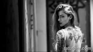Фотография девушки с татуировками в виде лиц на спине и руке, демонстрирующая загадочный и привлекательный образ.
