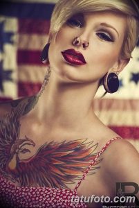 Фотография девушки с татуировкой орла на плече и шее на фоне американского флага, демонстрирующая патриотический и сильный образ.