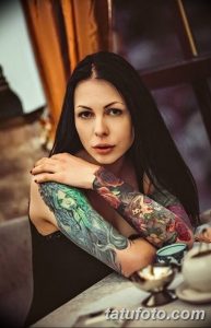 Фото тату на всю руку, сочетающее яркие цветы, мифических существ и элементы японской волны. Идеально для вдохновения и поиска идей для тату.
