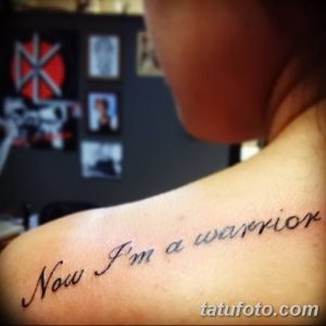 Фото тату: надпись 'Now I'm a warrior' на руке девушки, выполненная черными чернилами. Эскиз татуировки выполнен в каллиграфическом стиле.