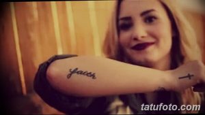 Фотография татуировки надписью 'faith' на руке женщины. Изображение сделано крупным планом, акцент на шрифте и расположении татуировки.