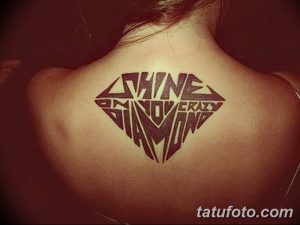 Фото тату: черный бриллиант с надписью "Shine on you crazy diamond" на спине. Стильный и запоминающийся дизайн.