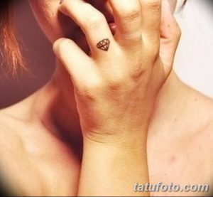 Фото тату маленького черного бриллианта на запястье. Минималистичная татуировка с четкими линиями.