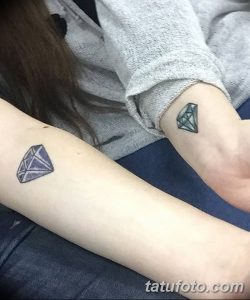Фото парных татуировок в виде бриллиантов на руках. Небольшие, минималистичные рисунки в фиолетовых тонах, выполненные в графическом стиле.