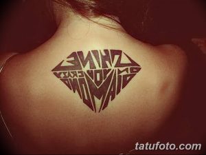 Фото тату бриллианта, заполненного надписью "Shine like a diamond", на спине девушки. Оригинальный рисунок татуировки, выполненный в черном цвете.