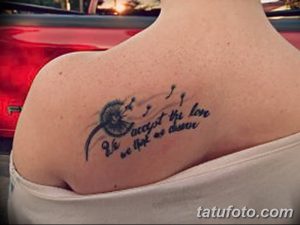 Фото тату одуванчика с надписью "Be accept the love we think we deserve" на плече. Рисунок выполнен в черно-белой гамме.