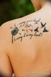 Фото тату одуванчика с цитатой и птицами на плече. Черно-белый рисунок с детальной проработкой одуванчика, летящих птиц и красивой каллиграфией.