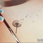 Фото минималистичного тату одуванчика на плече девушки. Нежный и изящный рисунок татуировки.