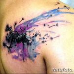 Фото акварельной татуировки одуванчика на плече. Яркий и красочный рисунок татуировки, выполненный в технике акварели, с использованием розовых и фиолетовых оттенков.