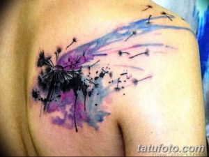 Фото акварельной татуировки одуванчика на плече. Яркий и красочный рисунок татуировки, выполненный в технике акварели, с использованием розовых и фиолетовых оттенков.