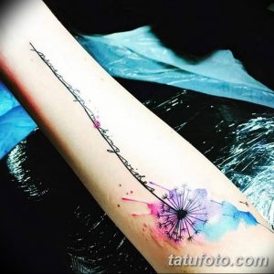 Фото акварельной татуировки одуванчика на предплечье с надписью "Never stop making wishes". Рисунок татуировки выполнен в нежных пастельных тонах.