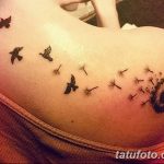 Фото тату одуванчика, из которого вылетают птицы, на плече. Изящный рисунок в черных тонах, символизирующий свободу и мечты.